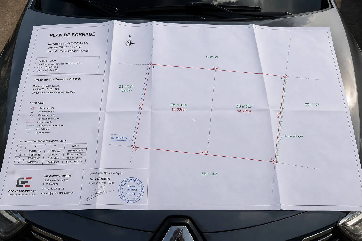 Plan de bornage deplie sur un capot de voiture